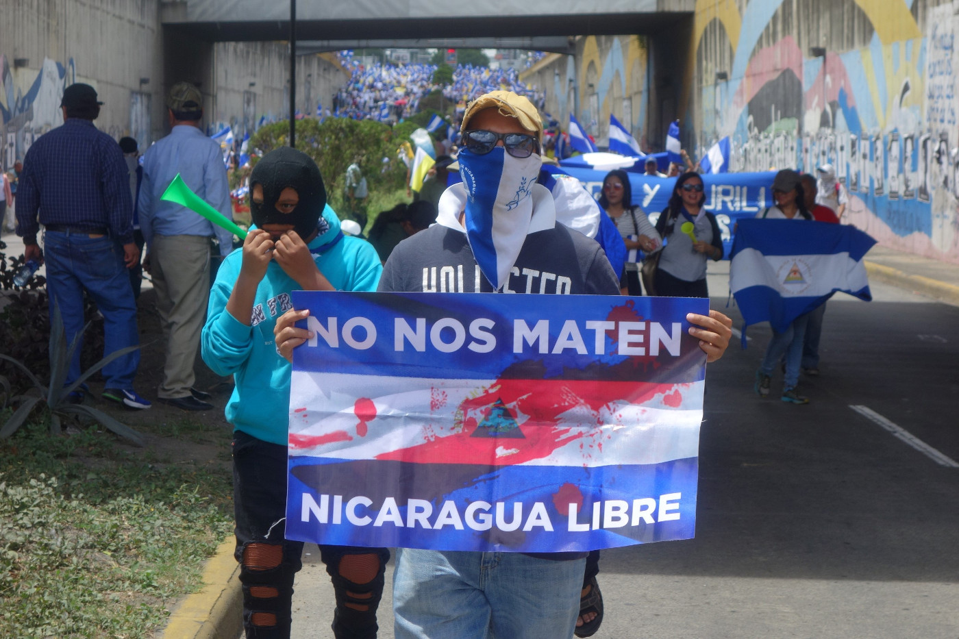 Zwei Vermummte in Nicaraguas Hauptstadt Managua auf der Demo vom 28. Juli 2018 zur Unterstützung der von der Regierung Ortega unter Druck gesetzten Bischöfe in Managua. Das Plakat sagt: „Bringt uns nicht um – Freies Nicaragua“. Foto: Adveniat/Klaus Ehringfeld