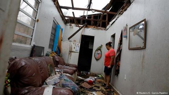 Eine Frau im zerstörten Haus ihrer Nachbarn nach dem Durchzug von "Maria". Foto: Reuters/C. Garcia Rawlins