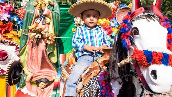 Guadelupe-Feierlichkeiten in Mexiko-Stadt: Familien lassen ihre Kinder auf einem Holzpferd vor einer Marienstatute fotografieren. Foto: Adveniat/Matthias Hoch
