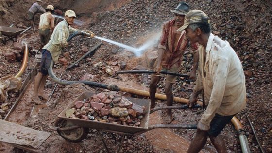 Goldschürfer in Brasilien bei der Suche nach dem Edelmetall. Sie versuchen mit Wasserdruck den Bodenschatz freizulegen. Foto: Adveniat/Bauerdick