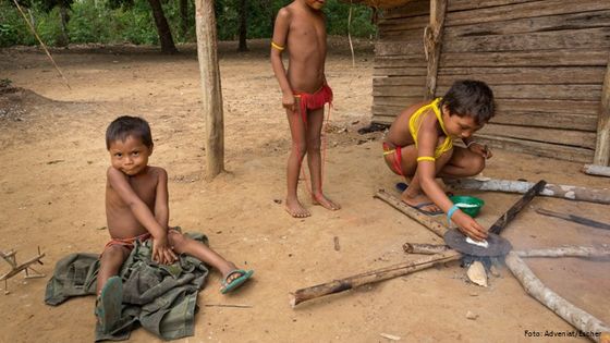 Kinder vom Volk der Yanomami im brasilianischen Amazonasgebiet bei der Zubereitung von Maniokfladenbroten. Foto: Adveniat/Escher