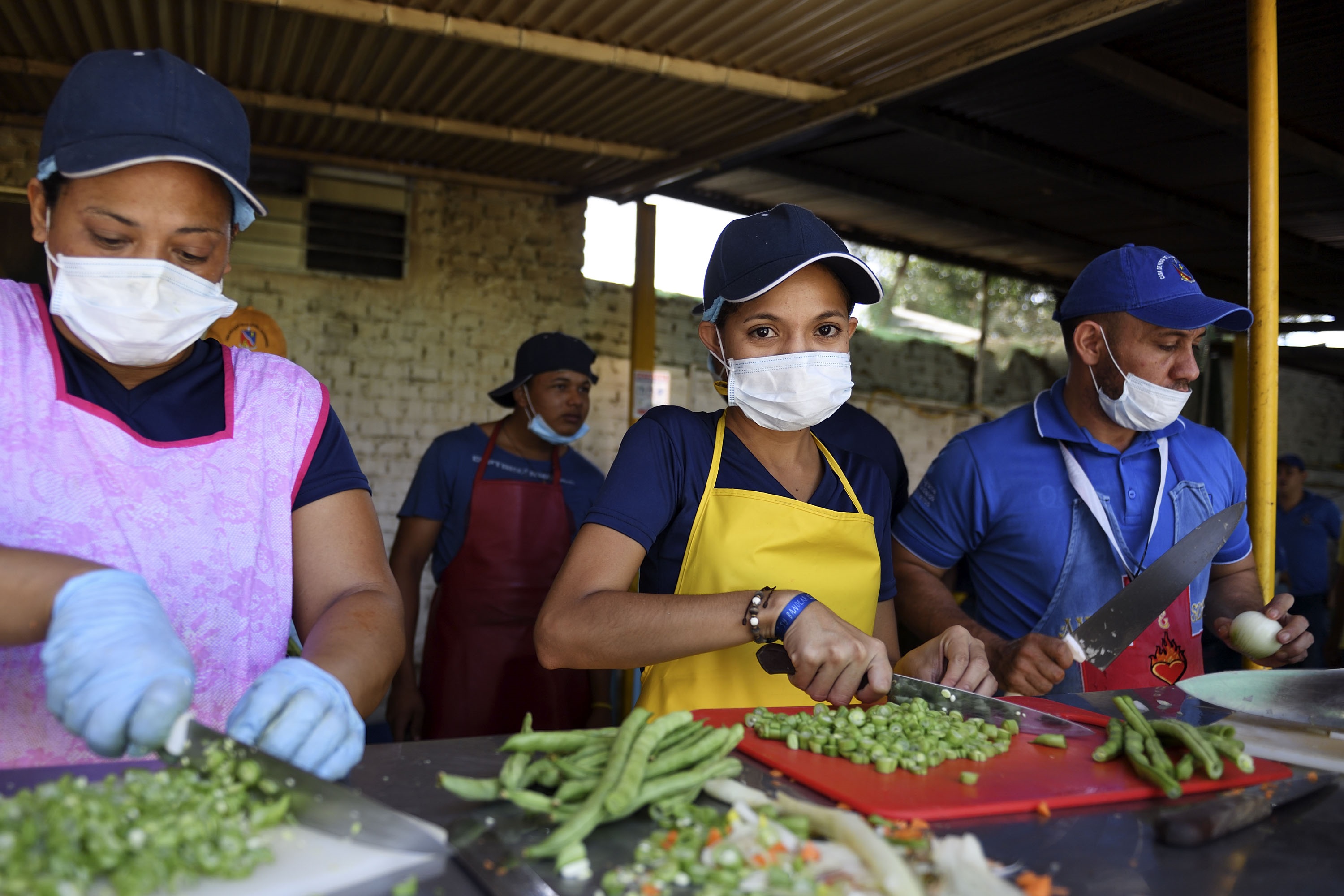 Mónica Jiménez (Mitte), 21, ist aus Maracay in Venezuela nach Cúcuta geflüchtet und arbeitet ehrenamtlich als Küchenhelferin bei der Versorgung der Flüchtlinge mit. Foto: Adveniat/Florian Kopp