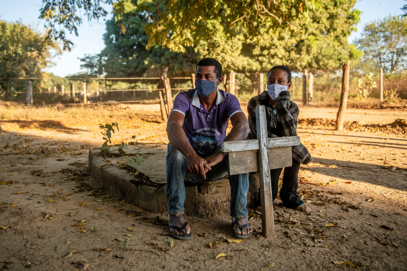 Dorfbewohner des Quilombo Balaeiro in Minas Gerais, Brasilien, sitzen mit Mund-Nasen-Schutz auf dem Friedhof. Foto: Adveniat/Florian Kopp