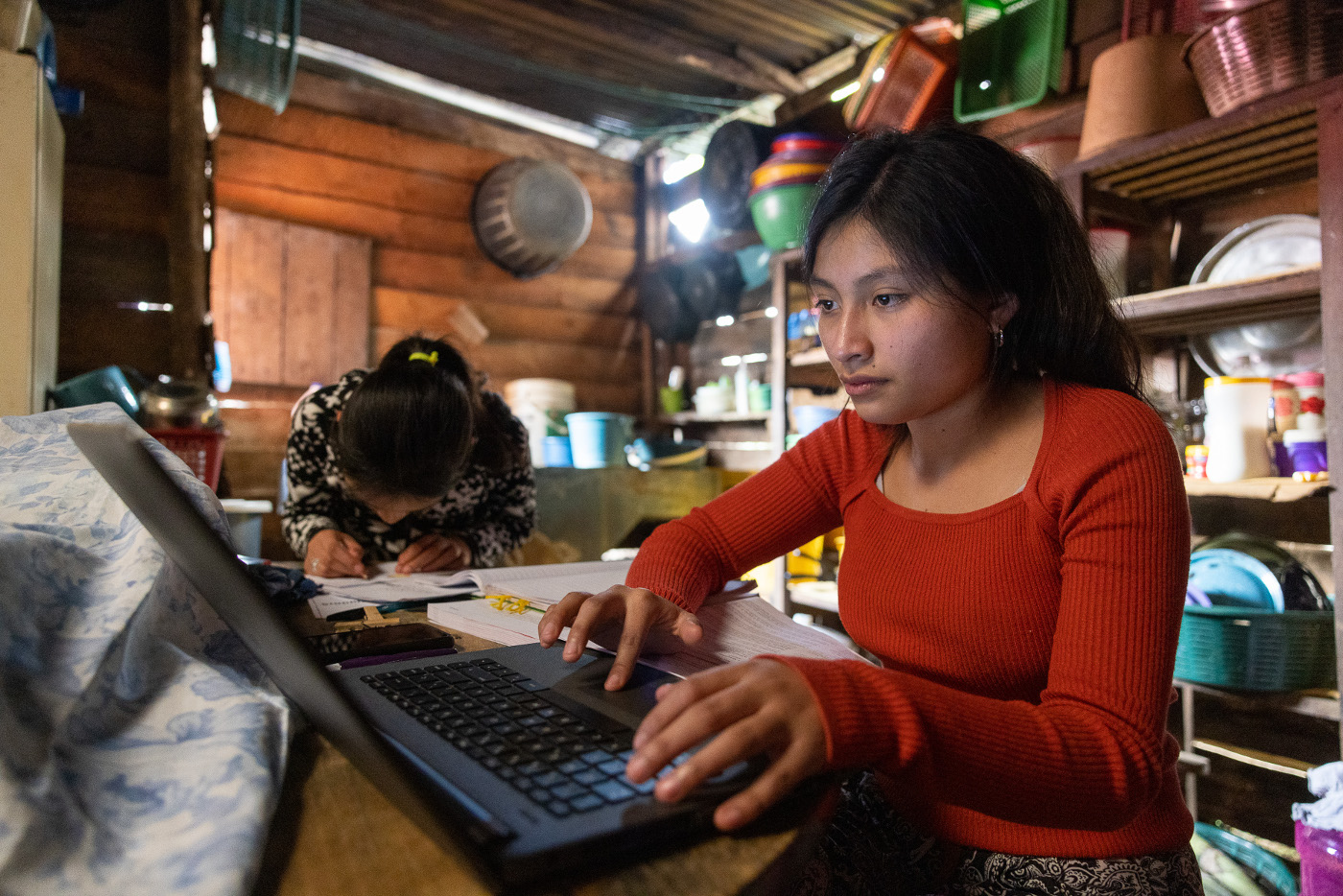 Familie Pacay - eine Mutter mit ihren vier Töchtern - lebt am Rand der Stadt Cobán, Guatemala, in einer aus Brettern zusammengezimmerten Hütte. Beim Hausaufgaben machen wird es eng. Foto: Adveniat/Achim Pohl