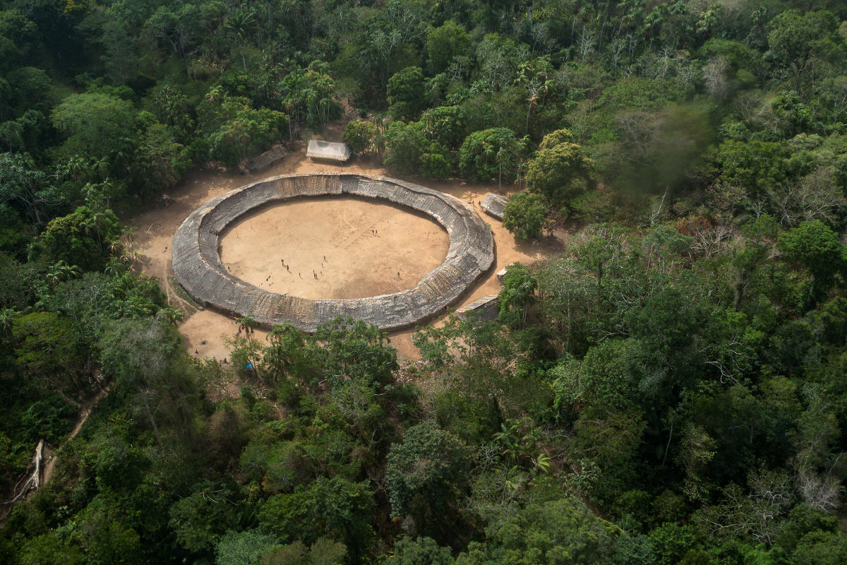 Aus der Luft fotografiert der Rundbau eines Yanomami-Dorfs im brasilianischen Amazonasgebiet. Die Yanomami pflegen ihre traditionelle, ursprüngliche Lebensweise, sind aber nicht isoliert. Foto: Adveniat/Jürgen Escher