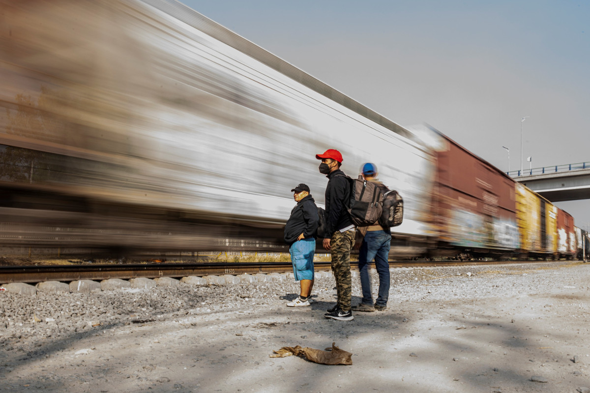 Migranten in Hidalgo, Mexiko, beobachten, wie ein Güterzug in hoher Geschwindigkeit vorbeifährt. Wenn der Zug zu schnell ist, können sie nicht aufspringen. Foto: Adveniat/Hans-Máximo Musielik